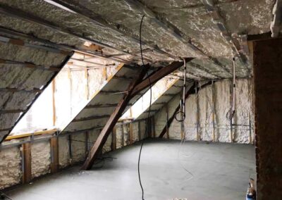 stěna v prostoru pod pultovou střechou s nánosem izolačního materiálu